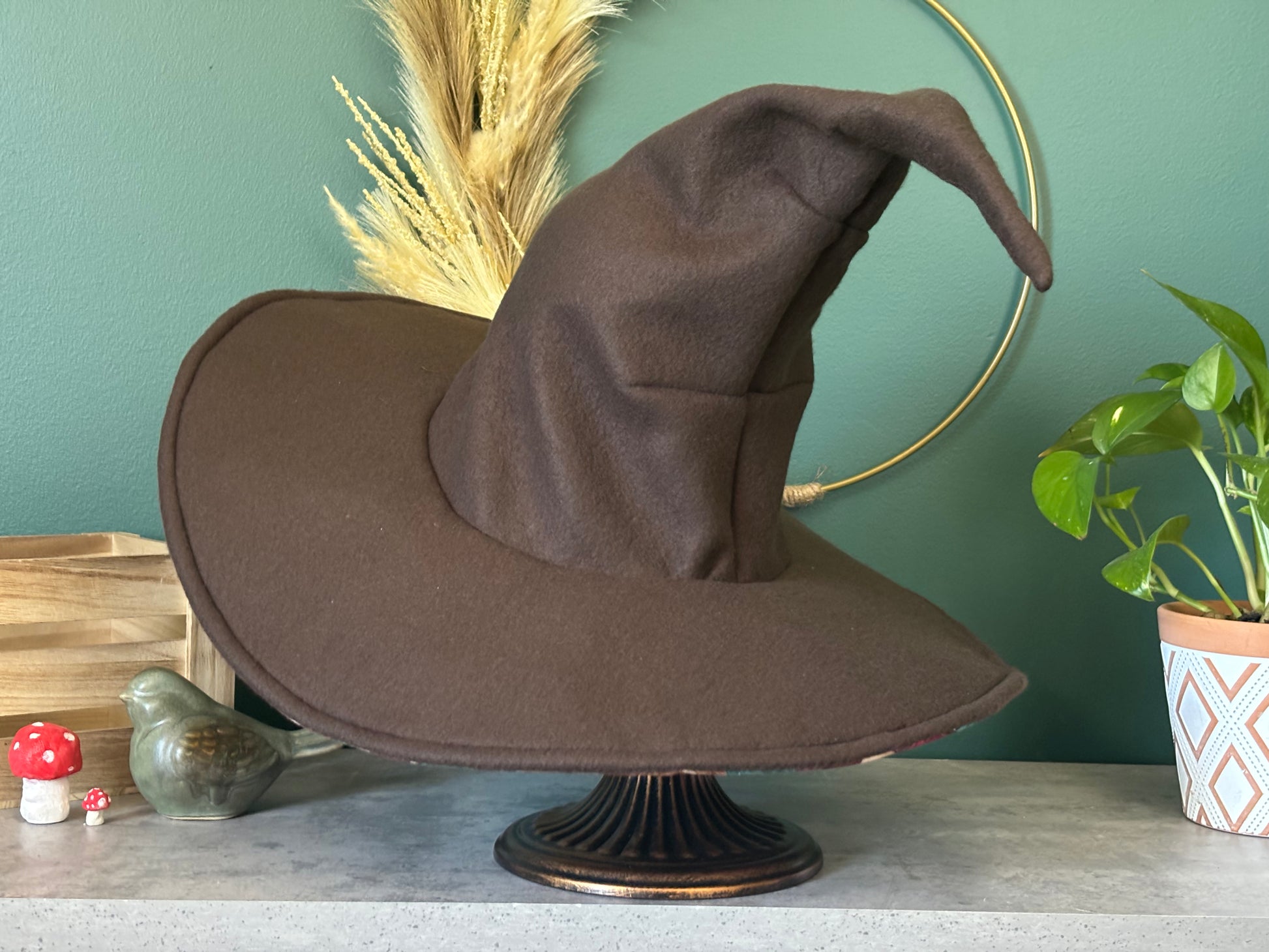 Dark brown witch hat or wizard hat made with soft fleece fabric, featuring a top cone section without any folds. The hat is customizable in various colors, including the underside of the brim, with additional fabric options available for a personalized touch.